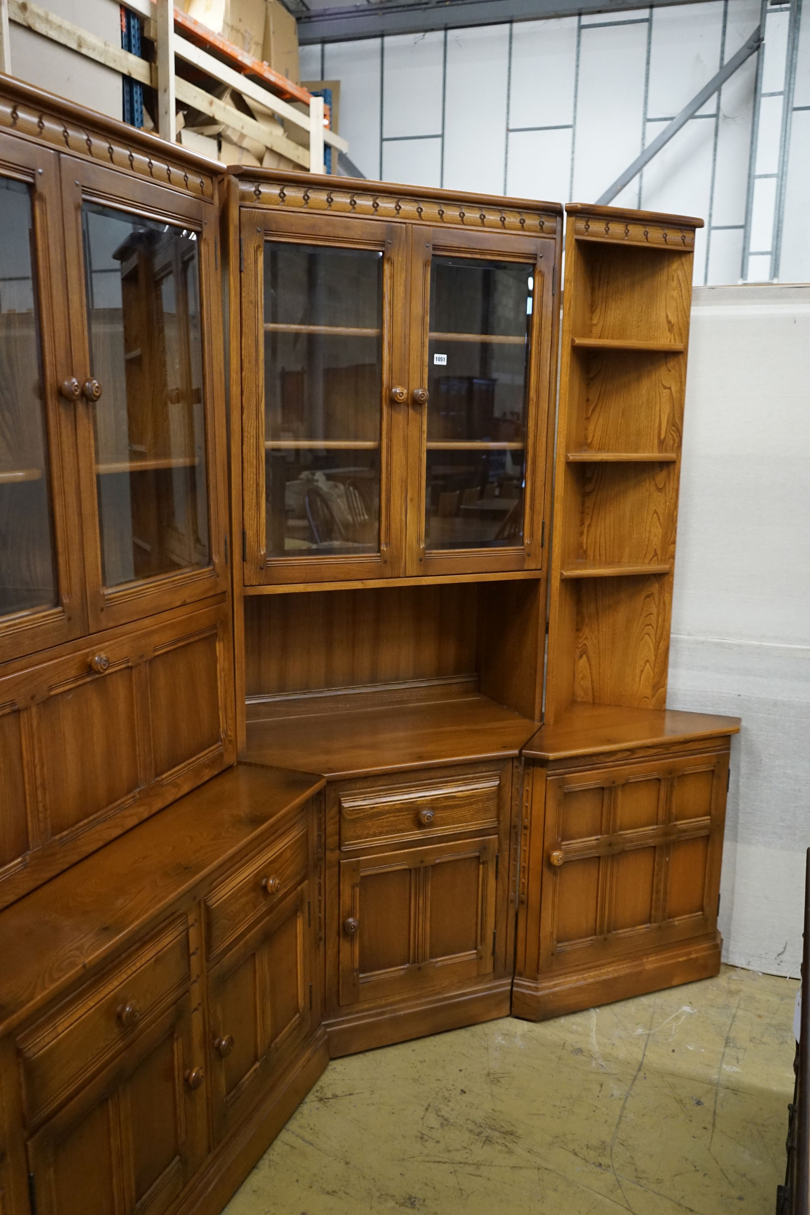 An Ercol elm four section modular wall unit, width 244cm, depth 49cm, height 197cm